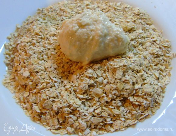 На тарелку насыпать овсяные хлопья, столовую ложку теста выложить и руками сформировать сырник.