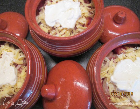 Теперь перетрем чеснок с солью и смешаем со сметаной. Уложим сверху в каждый горшок. Накрываем крышками и ставим в духовку на 50 минут при 180-190*С.