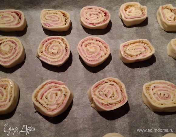 Нарезать рулет на ломтики, толщиной 1 см. Смазать желтком, смешанным со сливками или сметаной. Сверху можно посыпать кунжутом или семенами тмина.
