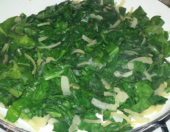 Тем временем к луку добавляем шпинат и тушим на медленном огне до мягкости.