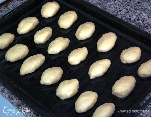 Включить духовку разогреваться до 180 градусов. Противень смазать маслом или застелить пекарской бумагой. Отрывая по-немногу теста, сформировать в руках пирожки размером чуть больше грецкого ореха. Выложить их на противень на расстоянии примерно 3 см друг от друга. 