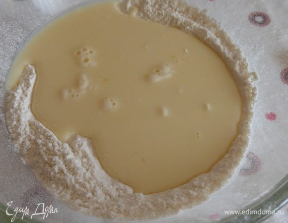 Просеять муку, добавить к ней соду, разрыхлитель, влить молочно-яичную смесь и хорошо перемешать. Тесто должно получиться по консистенции как густая сметана.