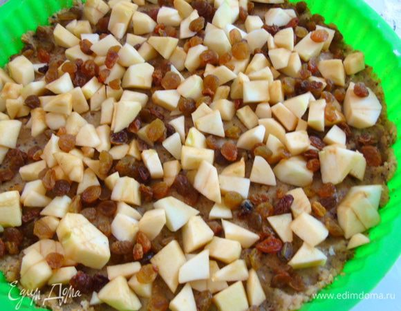 На тесто выложить яблоки и посыпать изюмом.