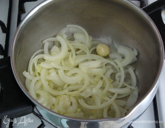 В кастрюле, где будет вариться суп, растопить сливочное масло. Обжарить на масле до прозрачности лук вместе с чесноком.