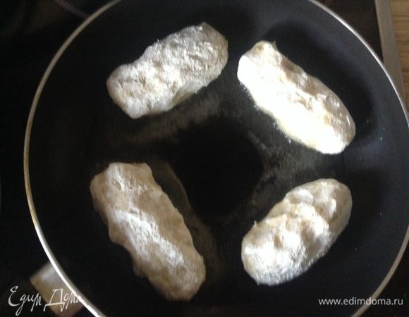 Влажными руками сформировать длинную лепешку положить сосиску, у меня маленькие (если фарш, то нанести тонким слоем, оставив немного край). Свернуть рулет, обвалять в муке, выложить на сковородку. Обжаривать быстро на большом огне, чтобы схватилось и подрумянилось