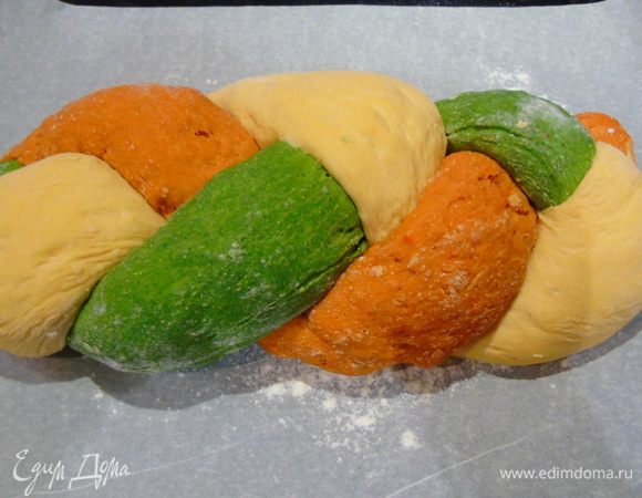 Заплетите в косу, края подогните. Выложите на противень, застеленный пергаментом, накройте полотенцем и дайте 30 минут подойти. Тем временем разогрейте духовку до 200С.