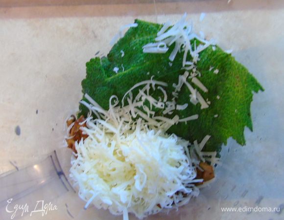 К зелени добавьте орехи, натертый пармезан, крошки, чеснок и оливковое масло.