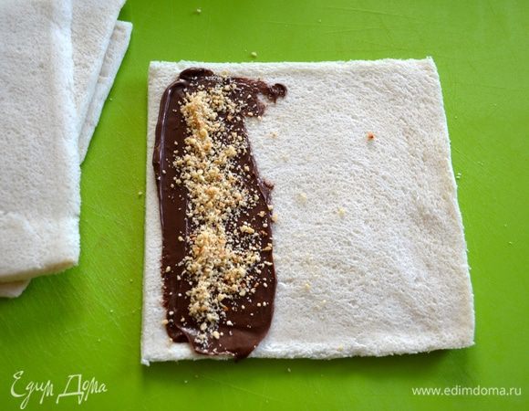 Наносим на один край шоколадно-ореховую пасту и щепотку измельченных орехов. У меня фундук, но это могут быть совершенно любые орехи (как собственно, и сами начинки!)