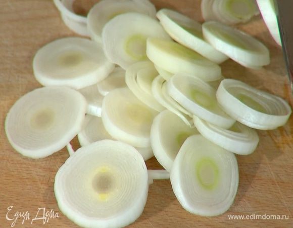 Светлую часть лука-порея нарезать кольцами.
