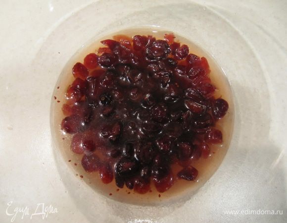 Залить вяленую клюкву яблочным соком, довести до кипения на сильном огне, снять с огня и оставить остывать на 10 минут.