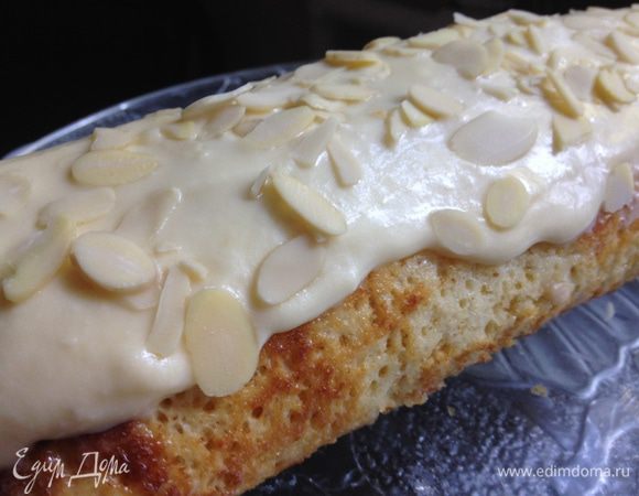 Кухонное полотенце намочить и хорошо отжать.
Горячий корж выложить на влажное полотенце, скрутить в рулет, подождать пока остынет. Раскрутить, намазать кремом (немного оставить для украшения), выложить на край банан и снова завернуть. Готовый рулет намазать кремом и притрусить орехами.