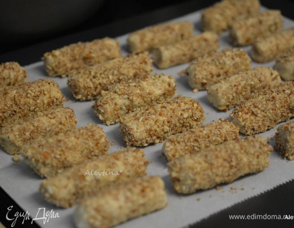 Выложить вторую часть пекана на тарелку. От теста отщипывать примерно по  кусочку теста 1 ст.л., например, скатывать тонко бревнышком и прокатывать по молотым орехам. Складывать на противень с бумагой для выпечки на небольшом расстоянии друг от друга. Так проделывать с каждым кусочком теста. 