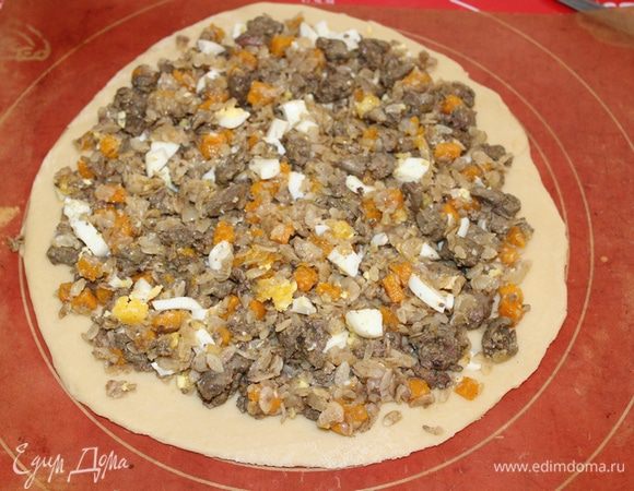 Готовое тесто обмять. Разделить на части. Раскатать, выложить на противень.
Равномерно выложить начинку, отступив от края теста пару сантиметров.