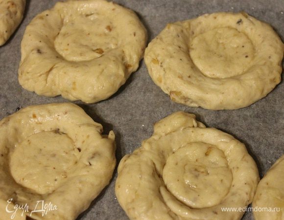 Подошедшее тесто разделить на 10-12 шариков. Противень застелить пергаментом и смазать 1 ст. л. растительного масла. Шарики из теста выложить на противень слегка приплюснуть ладошкой. Затем берем кружку или стакан и дном надавливаем на приплюснутые лепешки.