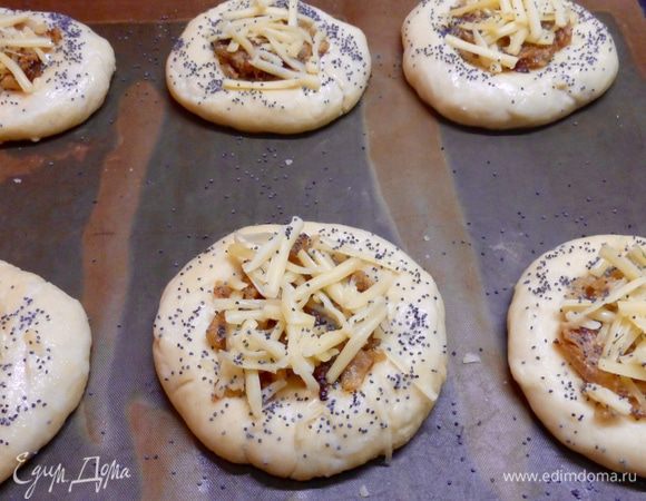 Разделить тесто на 12 — 16 равных частей, сформировать лепешки, положить их на противень, накрыть полотенцем и оставить для подъема на 30 минут. Сделать в тесте углубления, положить начинку и посыпать тертым сыром. Смазать края ватрушек молоком и присыпать сухим маком. Поскольку у меня семья небольшая, я все ингредиенты уменьшила в 2 раза и у меня получилось 6 ватрушек. Выпекать ватрушки в предварительно нагретой до 190 градусов духовке 20 — 25 минут.