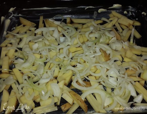 Противень смазываем сливочным маслом. Картофель моем (не чистим), нарезаем соломкой и выкладываем на противень. Лук режем не четверть кольца и выкладываем сверху.