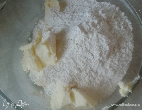 Замесить песочное тесто. Для этого в глубокую емкость просеять муку, разрыхлитель, добавить кусочки холодного масла и перетереть эту смесь пальцами до состояния крошки.