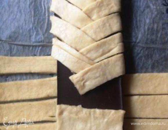 Сначала накрываем шоколад верхним и нижним полем, а затем начинаем попеременно укладывать на него боковые полоски, заплетая в косу.