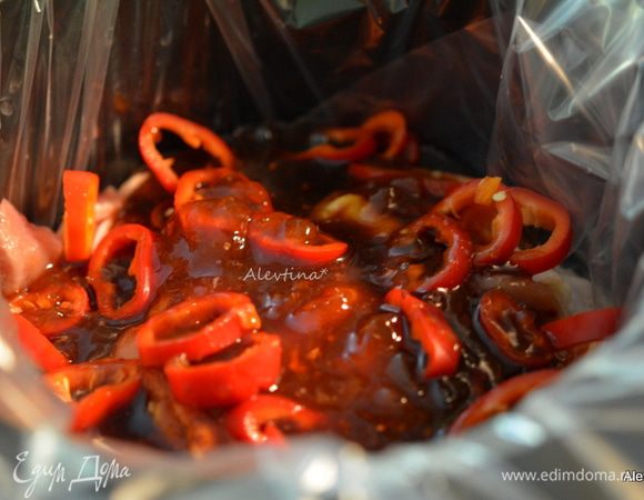 Выложить поверх лука и чеснока куриные бедрышки, полить соусом. Сверху выложить красный сладкий перец очищенный и порезанный. Закрыть крышкой и тушить на быстром режиме 3 1/2 часа или на медленном 5 1/2 часа.