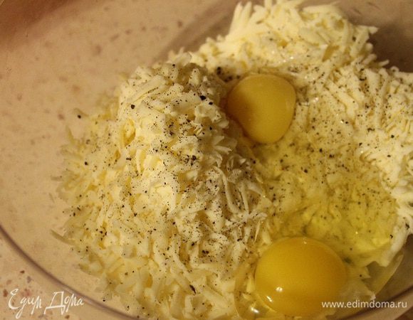 Сыр натереть на крупной терке. Яйца взбить с солью и черным перцем. Все вместе перемешать.