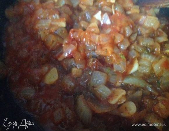Добавить томатную пасту, аджику, специи, нарезанный чеснок и обжарить еще несколько минут.
