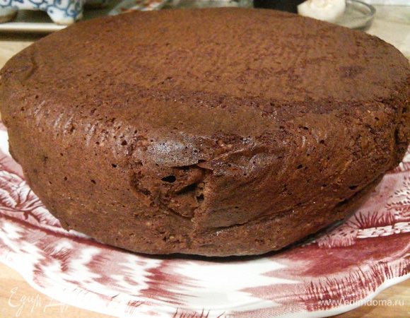 Готовый торт не вынимая из формы слегка остудите, затем извлеките из неё и выложите на блюдо, перевернув его верхом вниз (верхушка торта при выпекании немного вздулась и поверхность готового торта была бы покатой). 