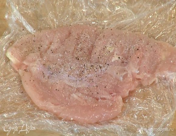 Куриное мясо поместить между двумя слоями пищевой пленки, отбить скалкой, затем посолить и поперчить с обеих сторон.