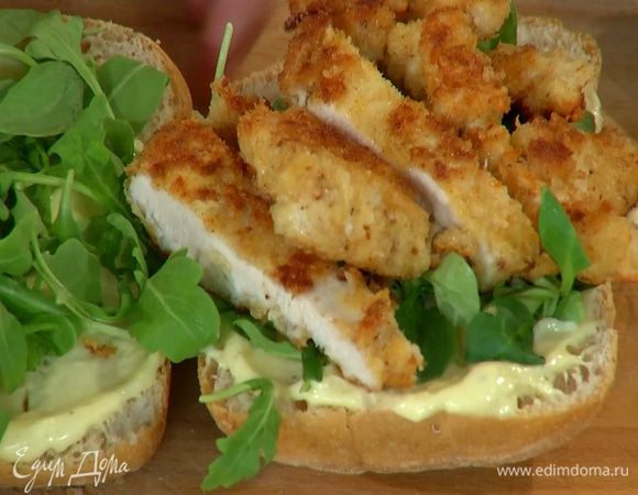 Куриное мясо нарезать полосками, выложить на одну половинку булки и накрыть второй половиной.