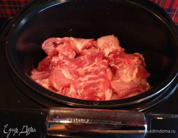 Дно мультиварки смажьте маслом, выложите лук, потом кролика.