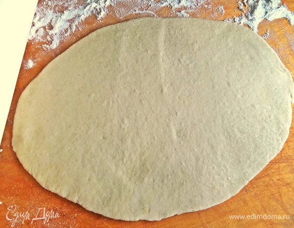 Раскатываем одну часть в тонкий овал.