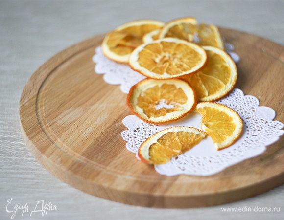 Нарезаем тонкими кружочками апельсин.
Выкладываем на противень в один слой и ставим сушиться при температуре 100-120 градусов около часа. Если дома влажно, то может уйти больше времени.
