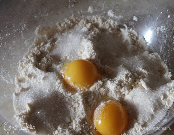 Муку с маслом перетереть руками в крошку. Добавить желтки, воду, сахар и соль.