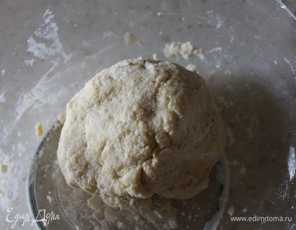 Замесить тесто. Накрыть или завернуть в ленку и отправить в холодильник на 30 минут. Охлажденное тесто раскатать и выложить в форму застеленную пергаментом (я брала форму d - 18 см). Сформировать бортики высотой 3 см, наколоть тесто вилкой и отправить в заранее разогретую до 190 градусов духовку, на 15 минут.