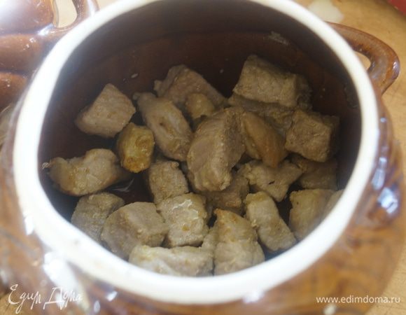 В предварительно подготовленные порционные горшочки, выкладываем мясо.