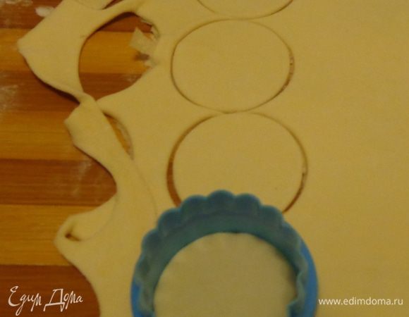 Слоеное тесто раскатать тонко и  формочкой вырезать кружочки.