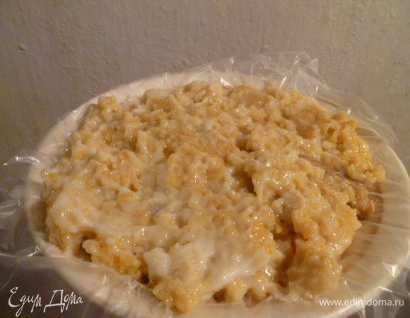 Остатки коржа я поломала и смешала с оставшимся заварным кремом, хорошо перемешала. Глубокую тарелку застелила пленкой, выложила крем с коржом и утрамбовала.