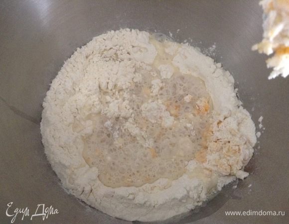 Муку просеять, добавить 70 г сахара, молоко, дрожжи, 1 яйцо и чуть-чуть перемешать.