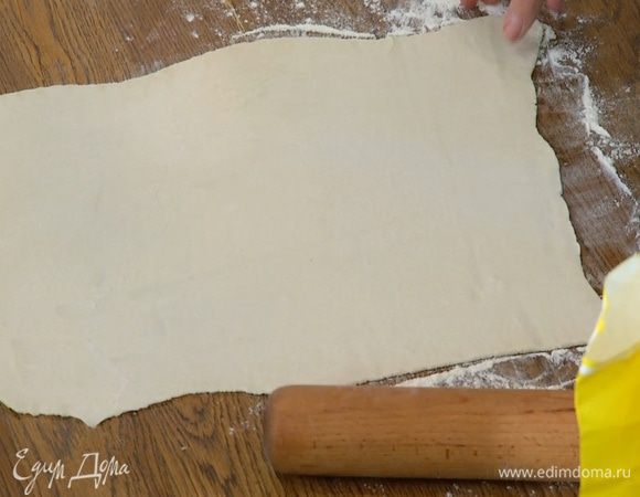 Рабочую поверхность присыпать оставшейся мукой и тонко раскатать тесто.