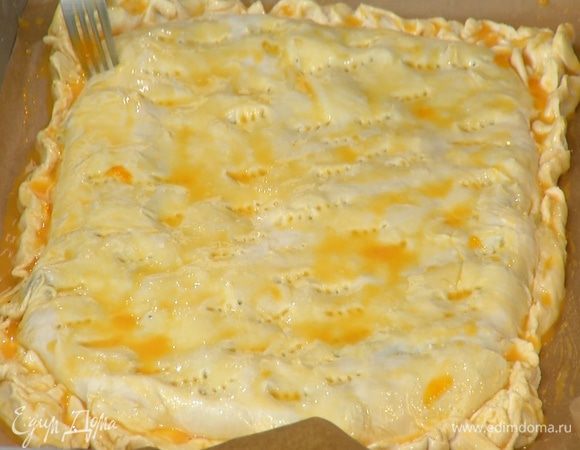 В яичные желтки добавить 1 ч. ложку молока, посолить, перемешать и с помощью кисточки смазать поверхность пирога, затем часто наколоть его вилкой.