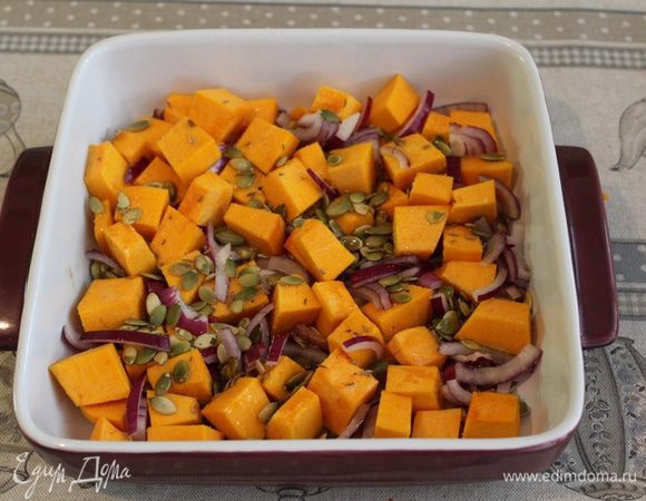 Тыкву нарежьте кубиками 1-2 см. Четверть лука нарезаем кольцами. 
Выложите тыкву, лук, тыквенные семечки и тмин в форму для выпекания. Посолите, поперчите и полейте оливковым маслом. Хорошо перемешайте и запекайте в духовке при 200С 15-20 минут, иногда помешивая.