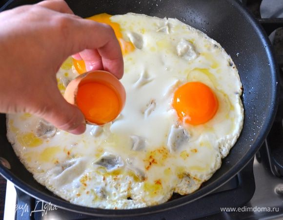 В разогретую сковороду, где обжаривались отбивные выложить белки. Дать им обжариться примерно минуту, и как только вы увидите, что белок "схватился", сделать тыльной стороной ложки небольшие 4 углубления и выложить в каждое из них по желтку. Слегка посолить и поперчить (по желанию), накрыть крышкой и дать обжариться буквально 1,5-2 минуты. 