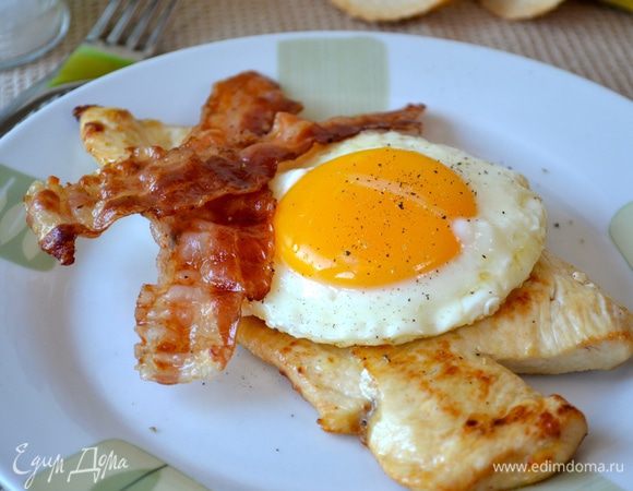 В тарелку выложить куриную отбивную, смазать ее немного горчицей (мои дети попросили соус "Песто") сверху выложить яйцо и полосочки бекона.
Приятного аппетита!