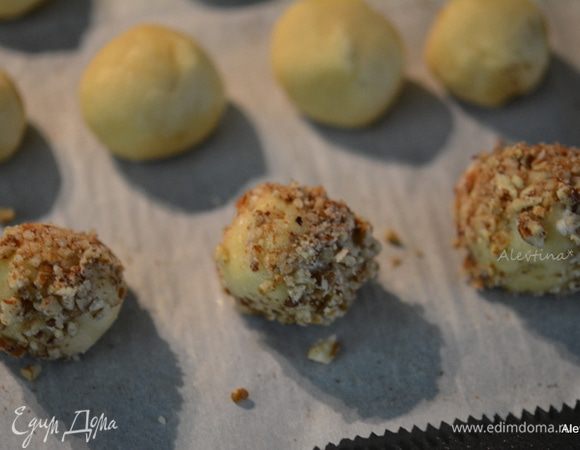 Затем каждый шарик окунаем в белок, а затем в орехи. И обратно на противень с бумагой для выпечки.