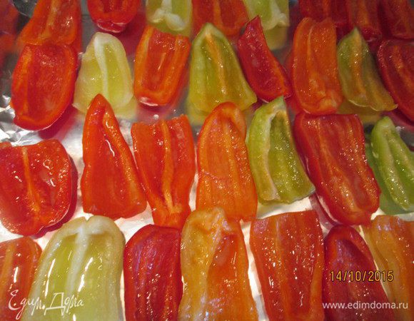 Выкладываем четвертинки замаринованных перцев на противень, застеленный фольгой.