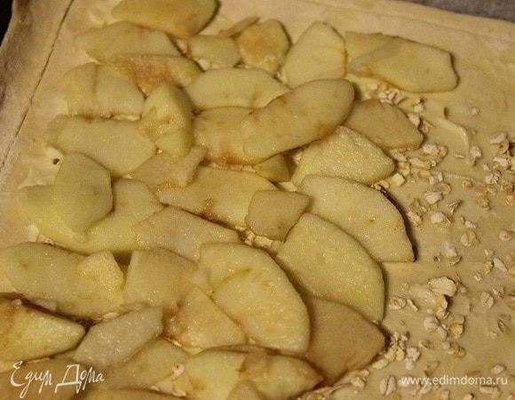 Сверху выложить нарезанные яблоки, добавить измельченные молотые грецкие орехи, лимонную цедру и посыпать корицей.