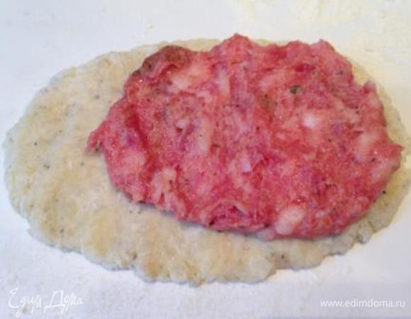 Раздавить кусочек теста в лепешку, выложить на нее таким же слоем фарш, не доходя до края 1 см.