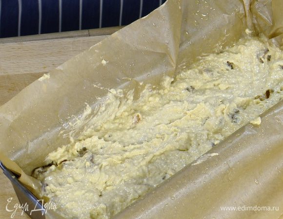 Продолговатую форму для выпечки выстелить пищевой бумагой, смазанной растительным маслом, выложить тесто и разровнять его.