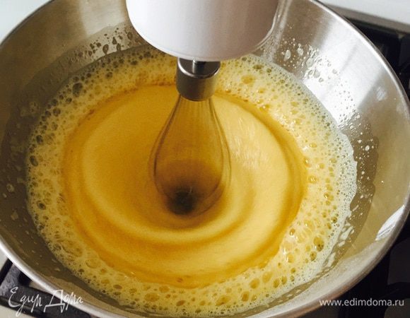 Начать взбивать яйца с сахаром до его растворения (на сайте было сказано, что очень важно именно взвешивать яйца, а не штуками измерять). Затем поставить чашу на водяную баню и продолжать взбивать, пока масса не станет температуры тела ;) Ну это примерно.