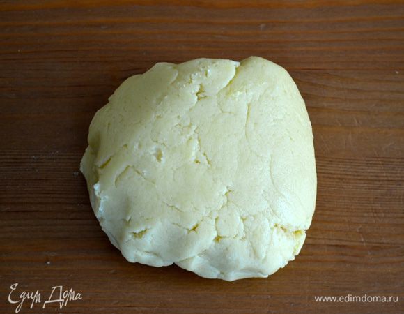 Приготовить тесто. Растопить сливочное масло, слегка остудить и смешать с яйцом и сахаром. Добавить муку с разрыхлителем и хорошо вымесить тесто. Я поручила приготовление теста как обычно блендеру... Тесто получается очень приятное! Выложить тесто на рабочую поверхность и раскатать на листе пекарской бумаги.