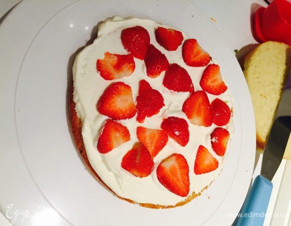 Ну все, собираем тортик: нижний корж перевернуть, промазать кремом, распределить лепестки клубнички.